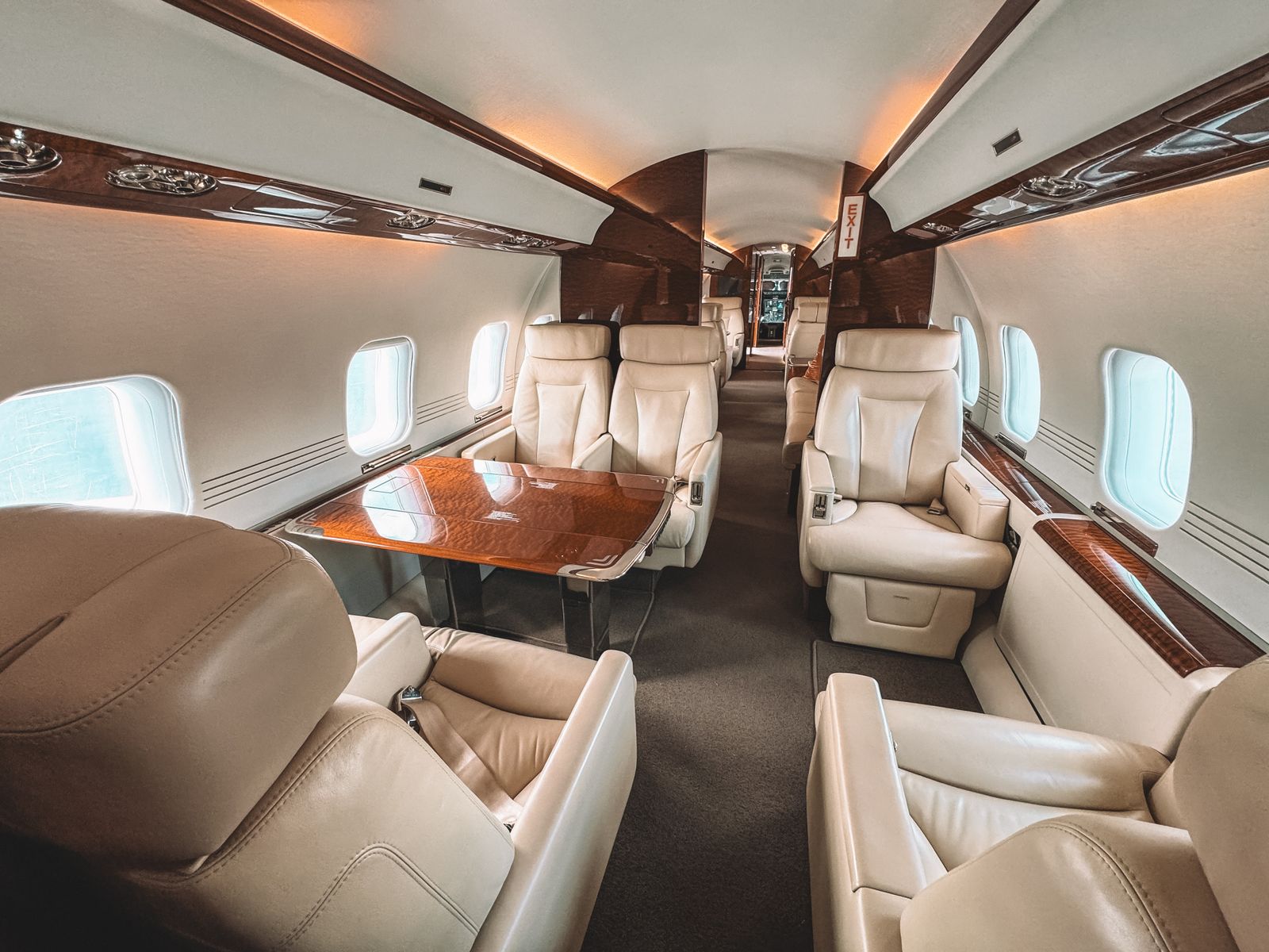 Interior de cabina de un jet ejecutivo, con asientos de piel y acabados en madera pulida